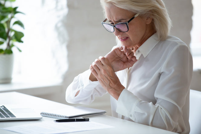 Corporate woman with wrist pain at work